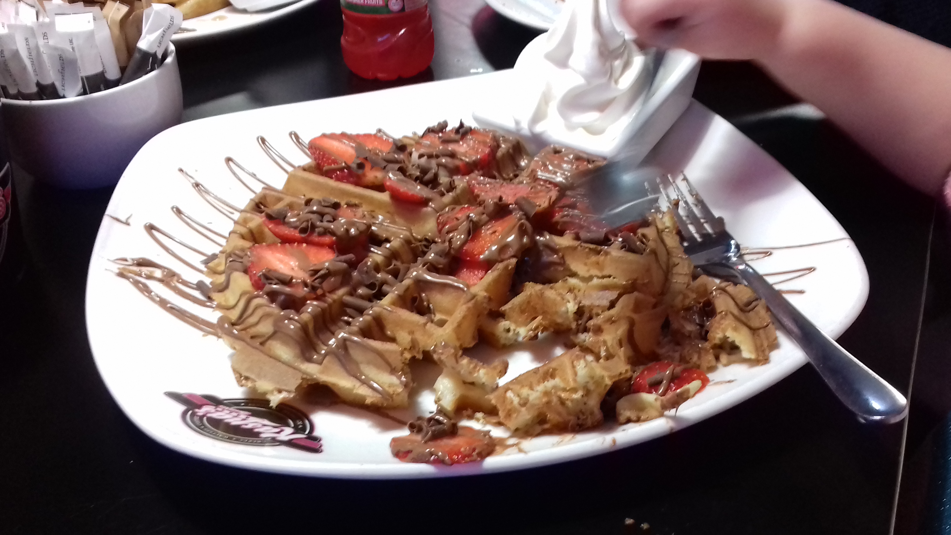 A giant waffle with strawberries and cream