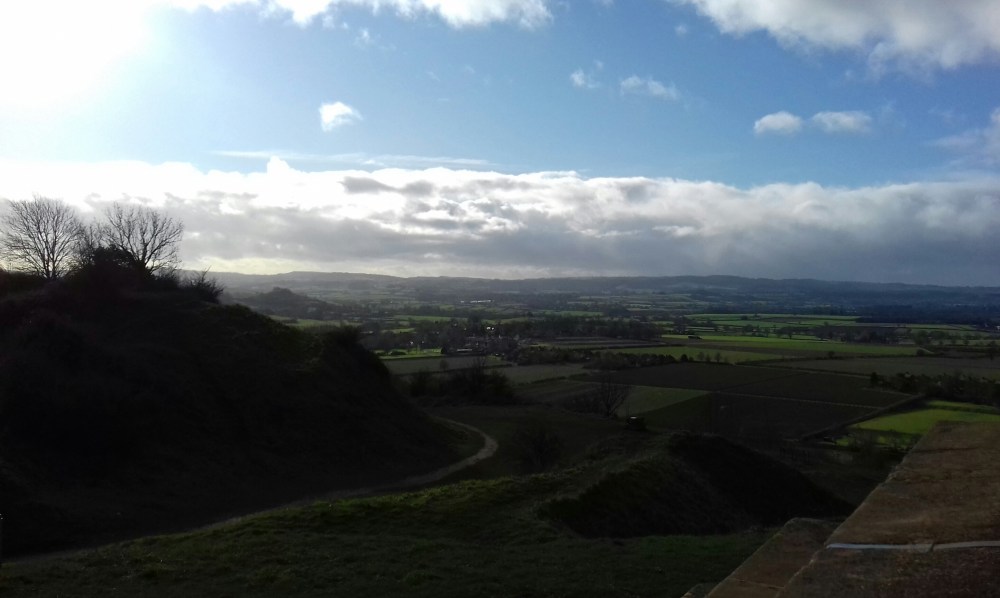 A landscape with clouds backed by sun