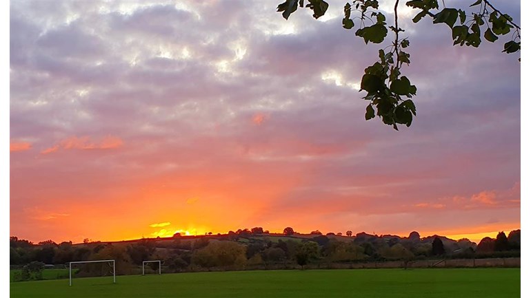 A picture of the sunset over a field 