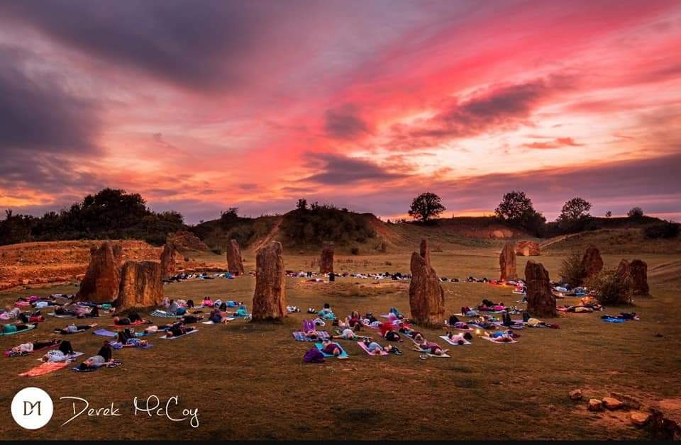 A pink sky with the stone circle at Ham Hill and yoga mats