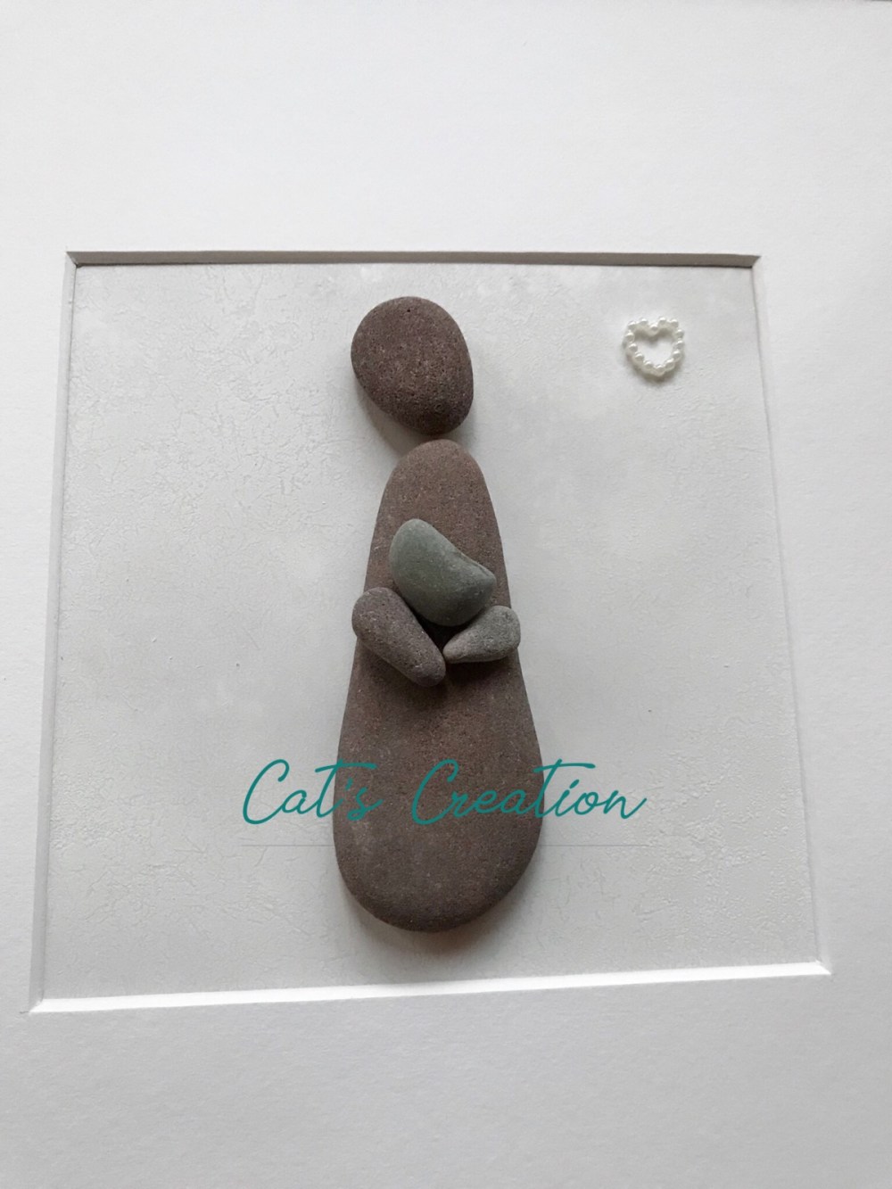 A pebble mother and child in a white frame 