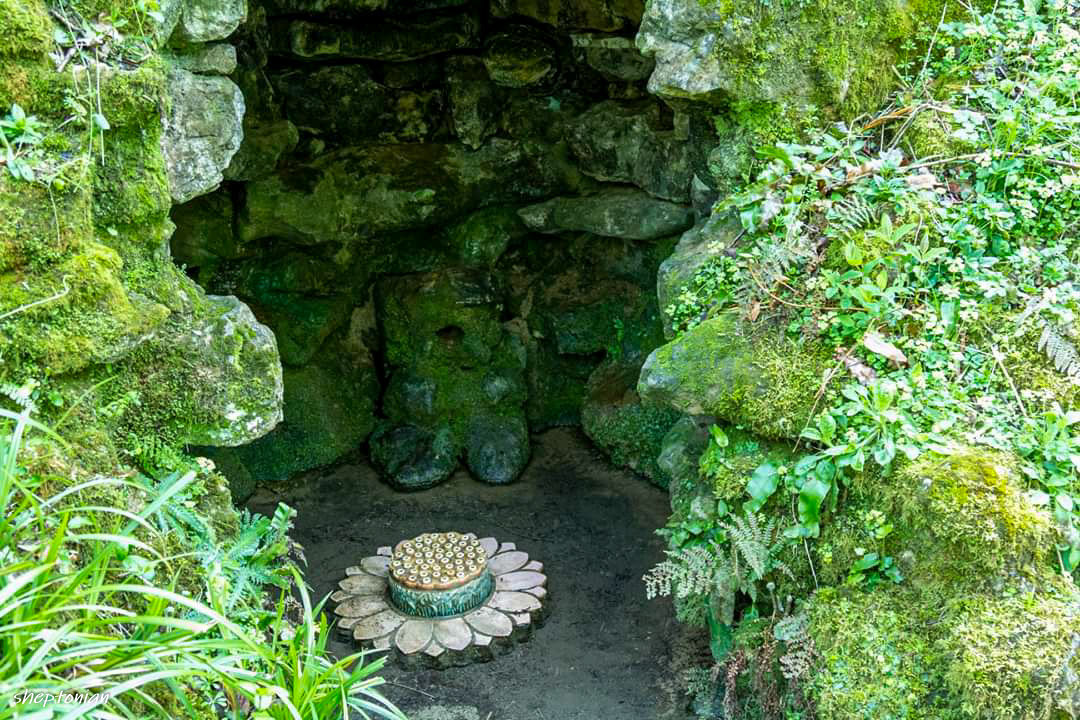 A small grotto with red and white stone flower stepping stone