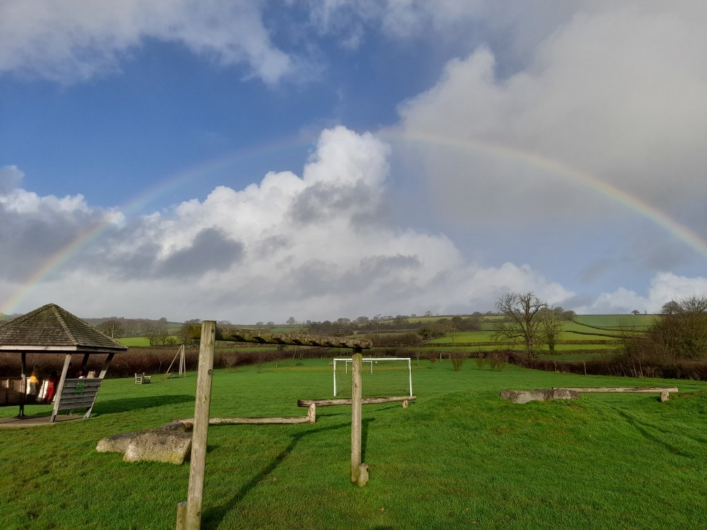 Rainbow over a field with play equipment