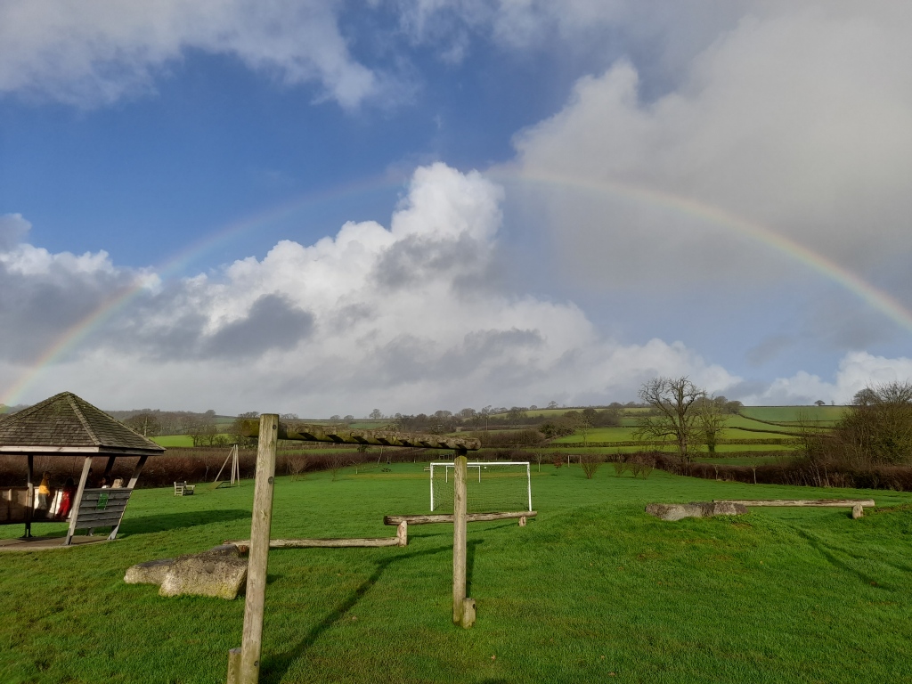 Rainbow over a field with play equipment