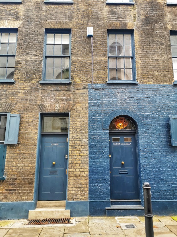 Brown brick building next to a building painted navy blue