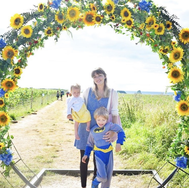 Wendy and two of her kids in a circle of sunflowers