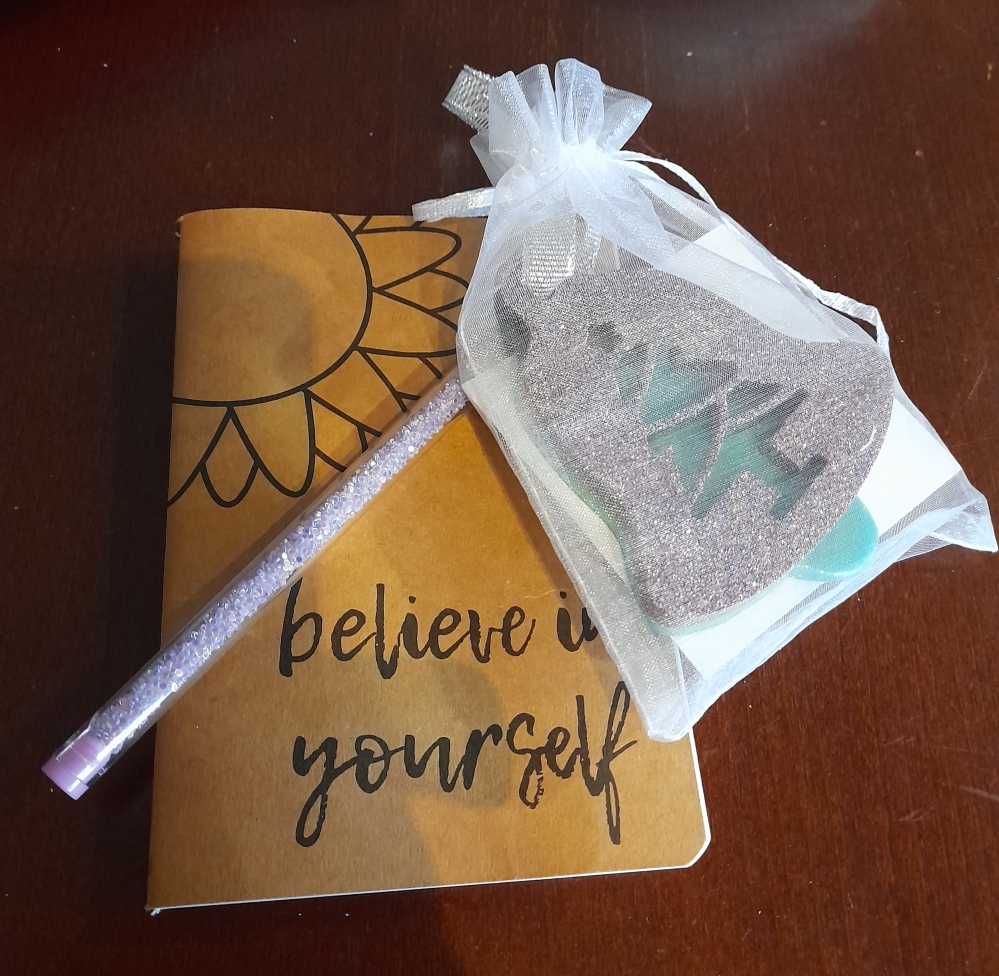 Small notepad with belive in yourself and a little gift bag with a glittery Christmas decoration and chocs