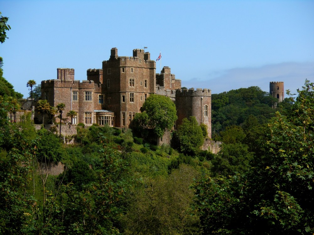 A grand looking bailey castle in orange brick amongst the trees