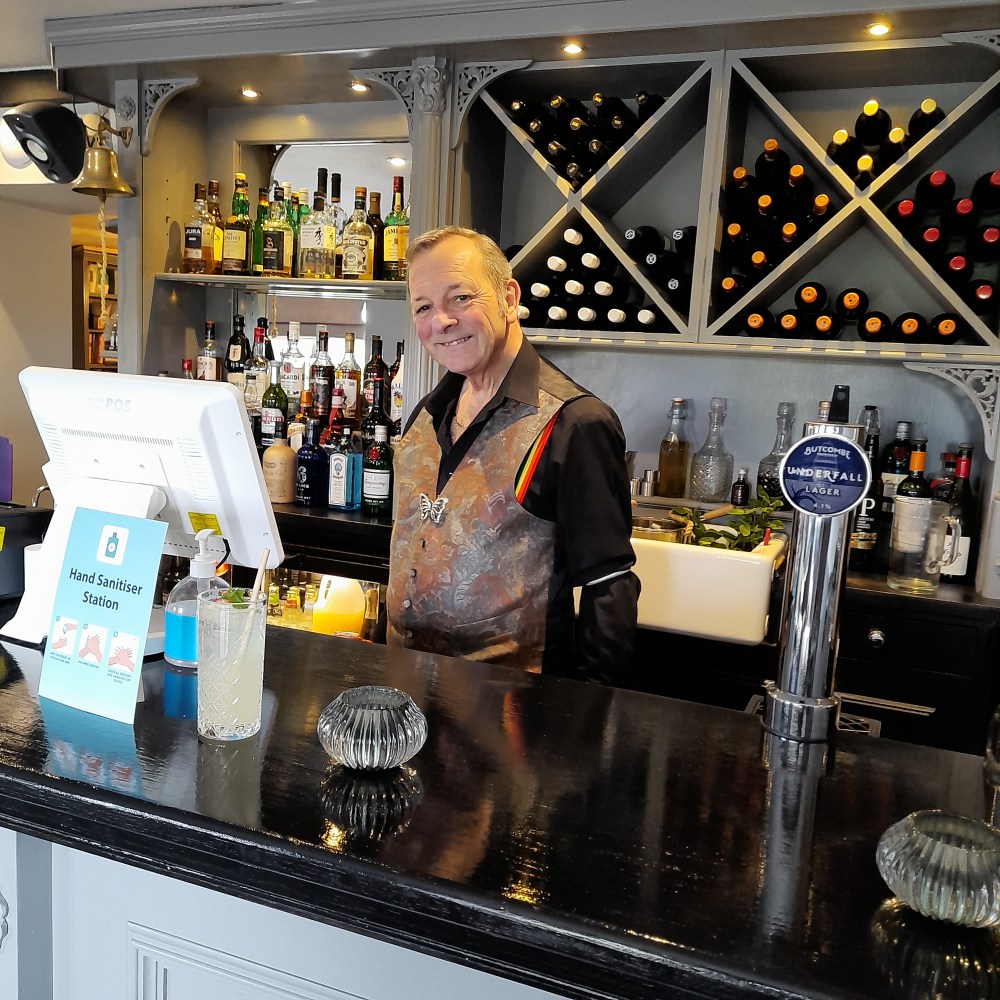 John standing proudly at the bar finely dressed in a waistcoat