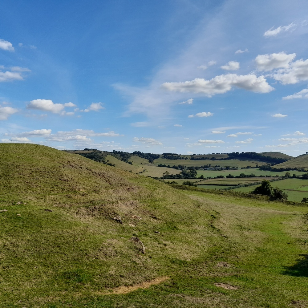 A bright clear day on Cadbury Castle with a gentle sloping landscape