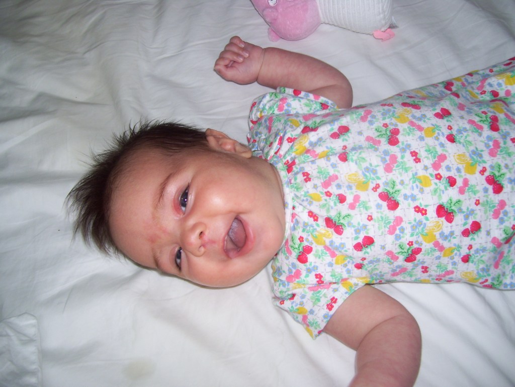 A smiling baby with plenty of dark hair!
