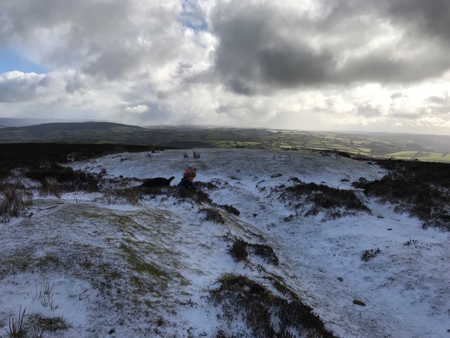 Rugged wintery views of vast Exmoor with clouds above and snow on the ground